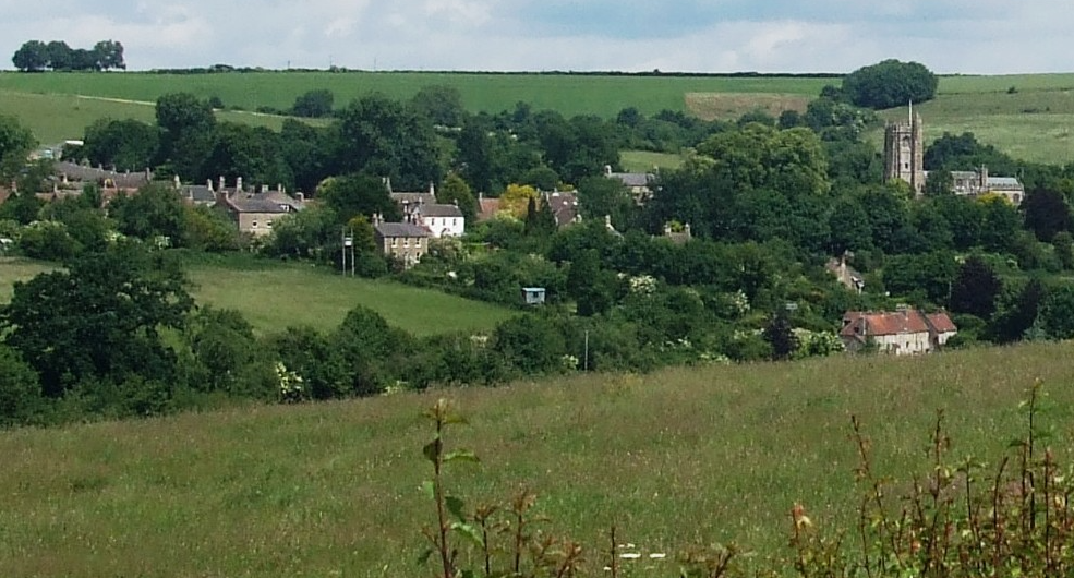 The village of Wellow, Somerset, set in a green valley and viewed from a distance