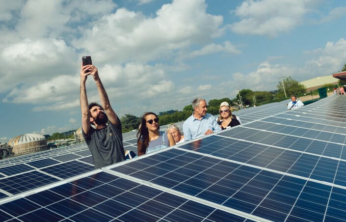 A group of people on a tour of a solar farm.