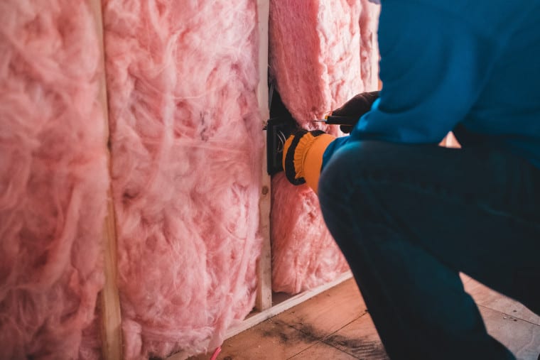 Someone installing wall insulation