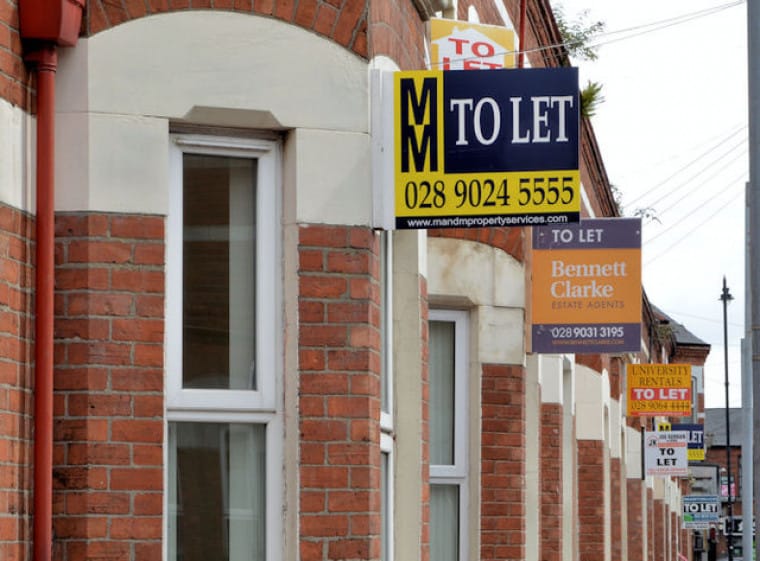 A row of terraced houses with 'to let' signs outside