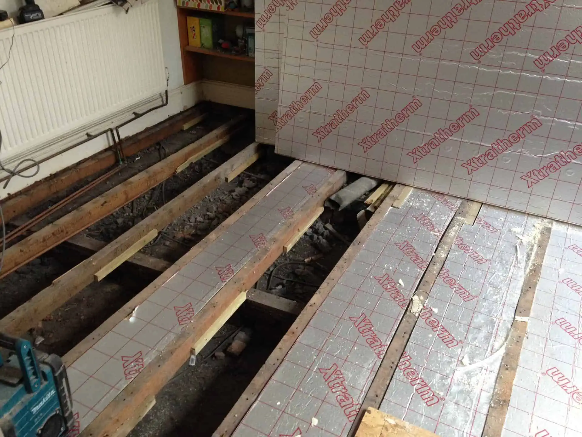 Foam insulation boards are laid between the floor joists