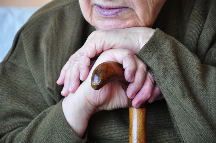 Close up of hands on a walking stick