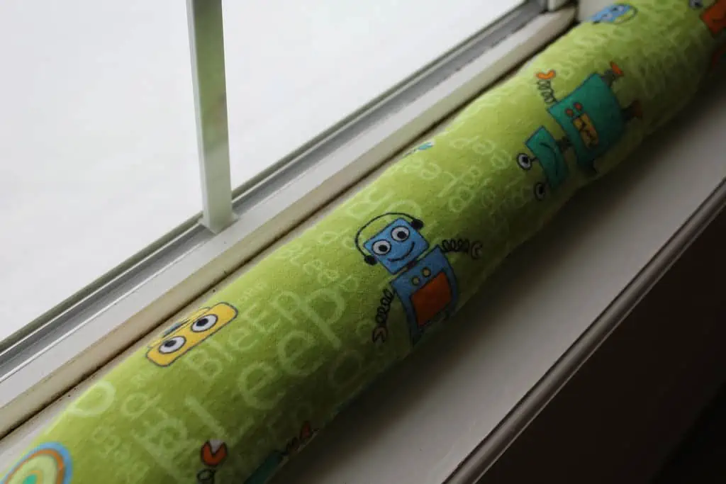 A home-made draught-excluder on a windowsill.