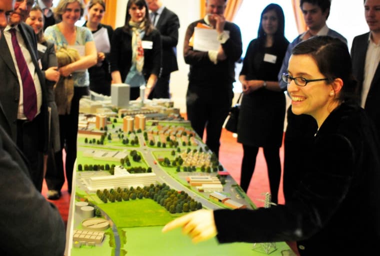 A consultation workshop. People gathering around a model of the city