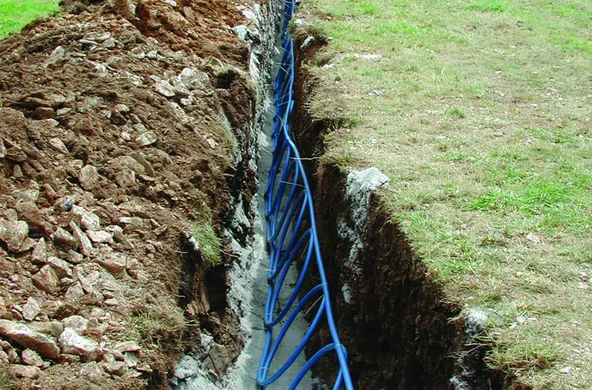 A trench in the earth containing the slinky-type pipework required for a ground source heat pump
