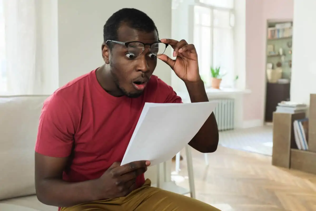 A man looks surprised at a bill he has been given