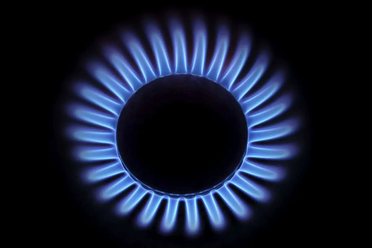Flame from a gas cooking ring glowing in the darkness, seen from above.