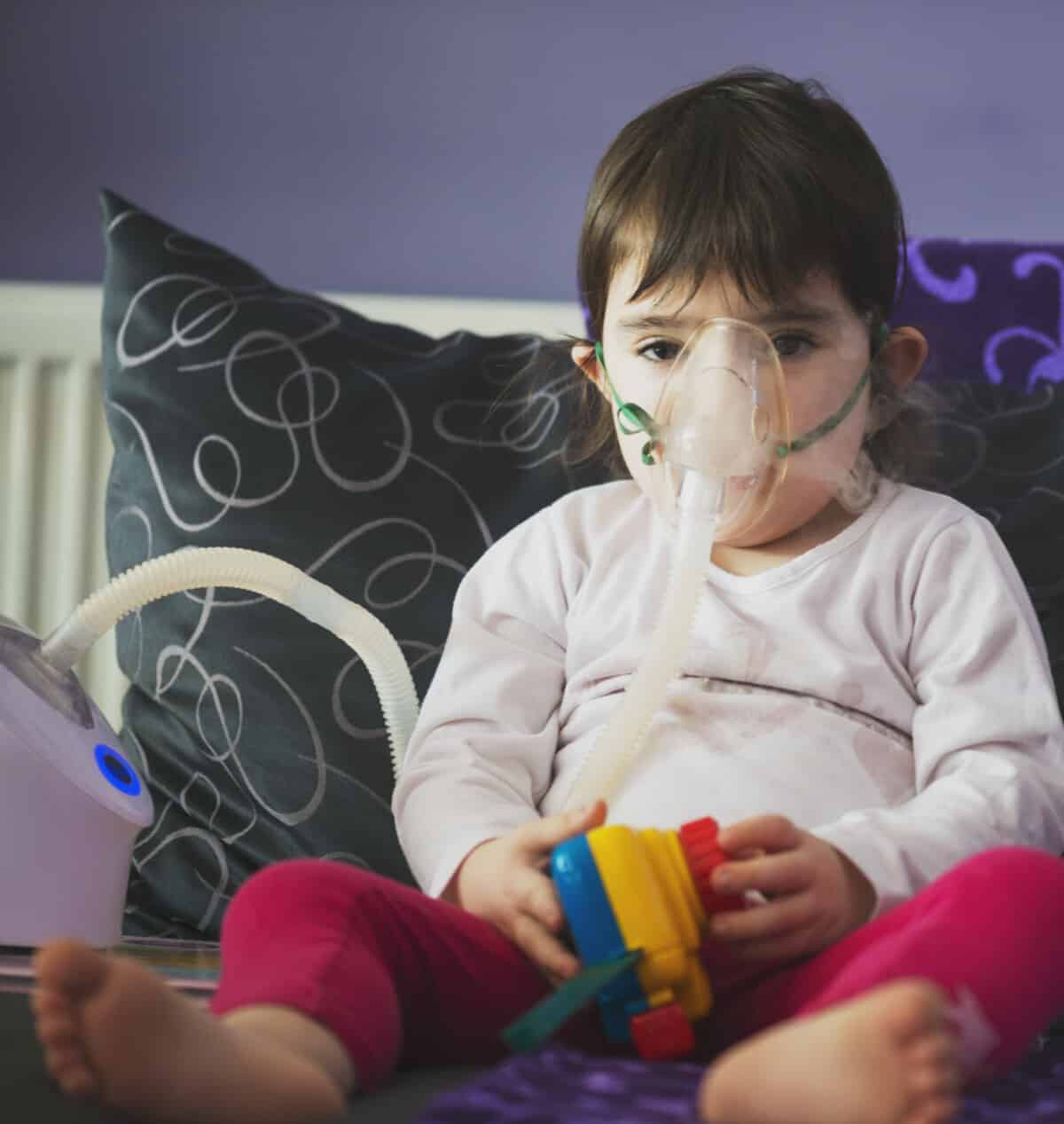 A child using an inhaler. Households including young children or anyone with a health condition, can sign up for their energy company's priority services register