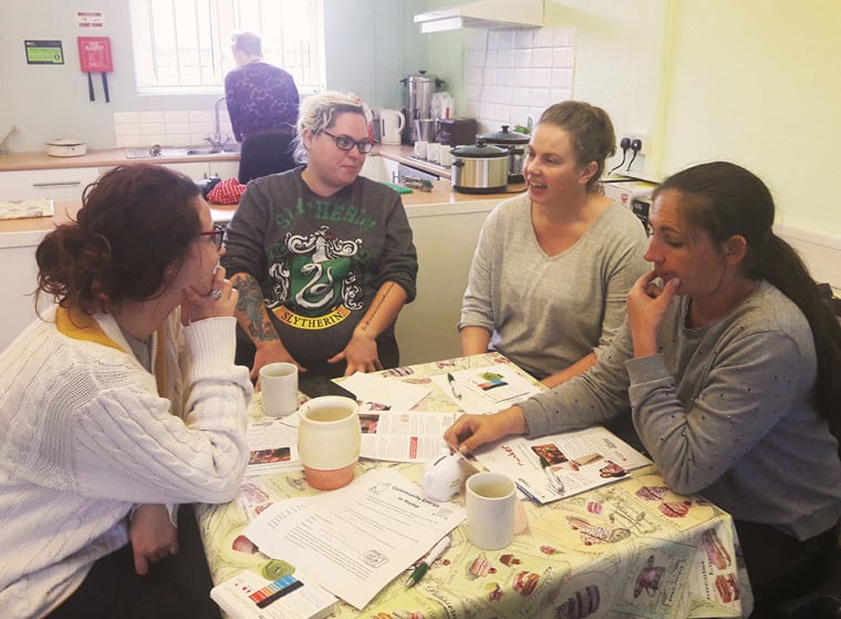 A group of women around a table in the kitchen of a community centre