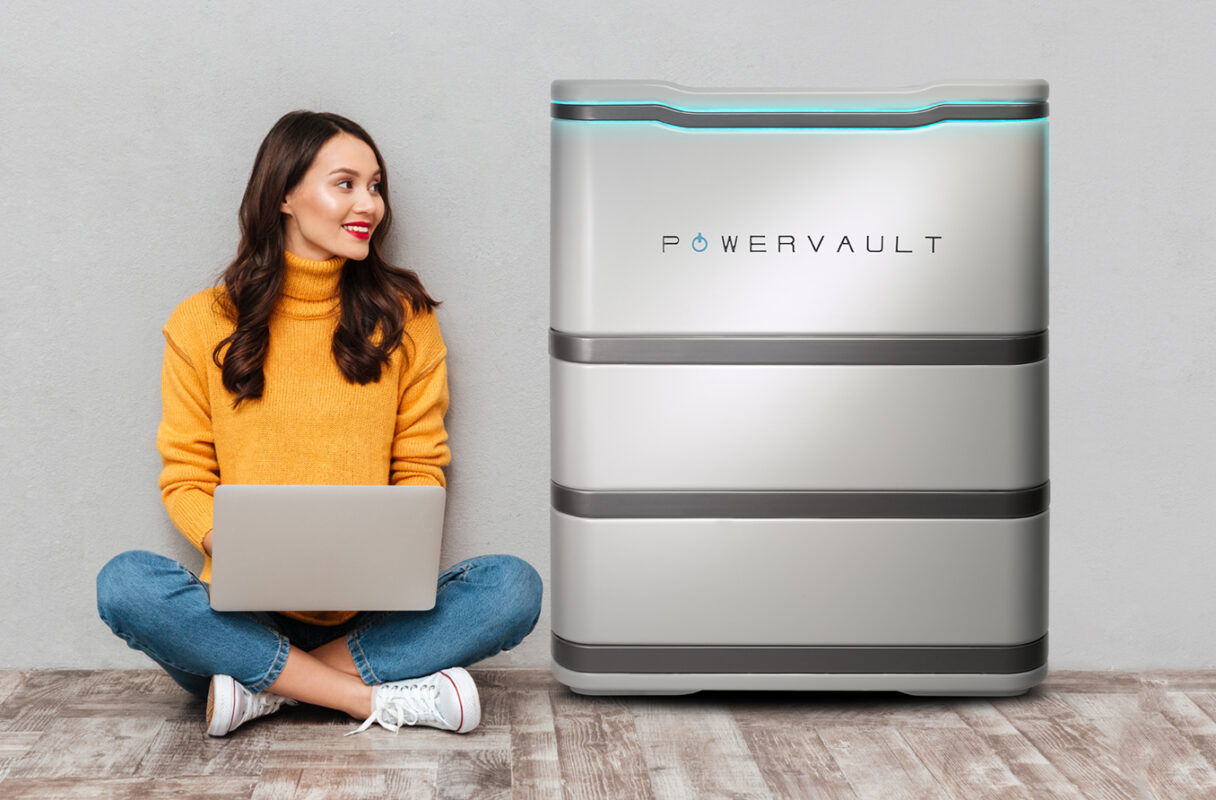 A women sits on the floor next to her home battery storage system (credit: Powervault).