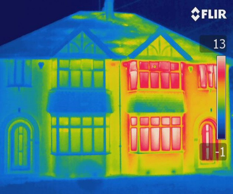 thermal sensor image of a large house. Windows on the right side of the property are bright red, on the left they are blue and yellow.