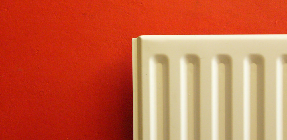 Radiator against a red wall. 