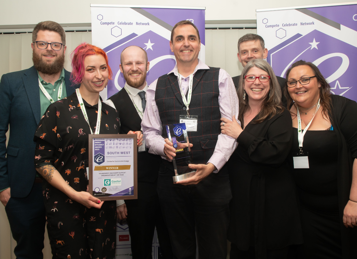 A group of smiling people accepting their award.