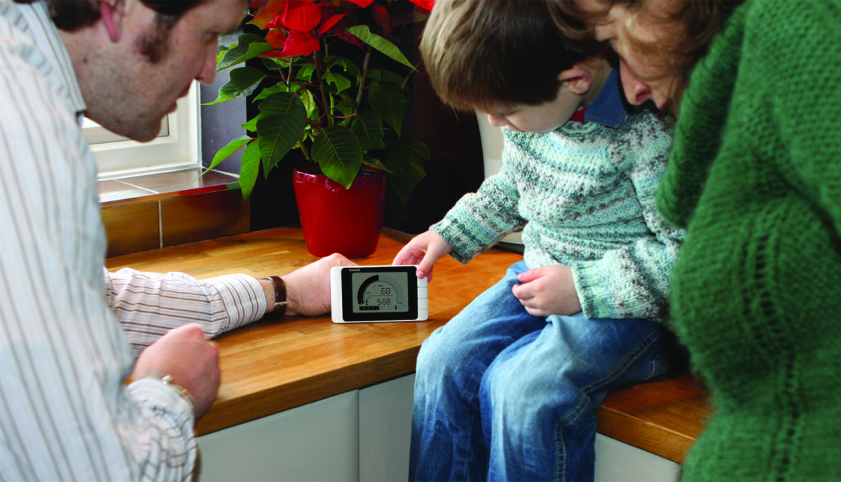 A young boy and his parents looking and pointing at a smart energy meter.
