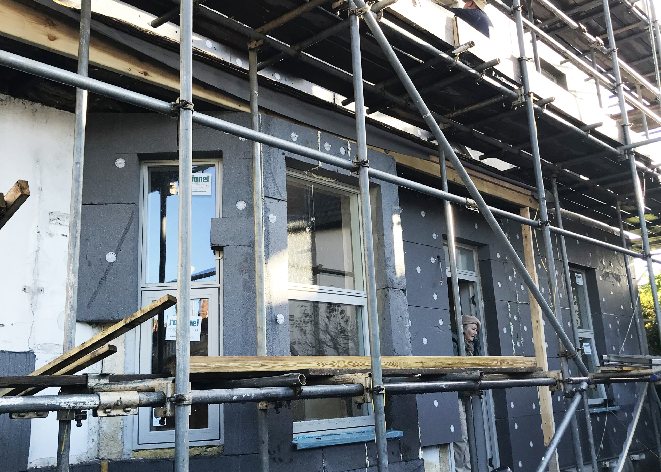 Scaffolding around a home that his having external solid wall insulation installed.