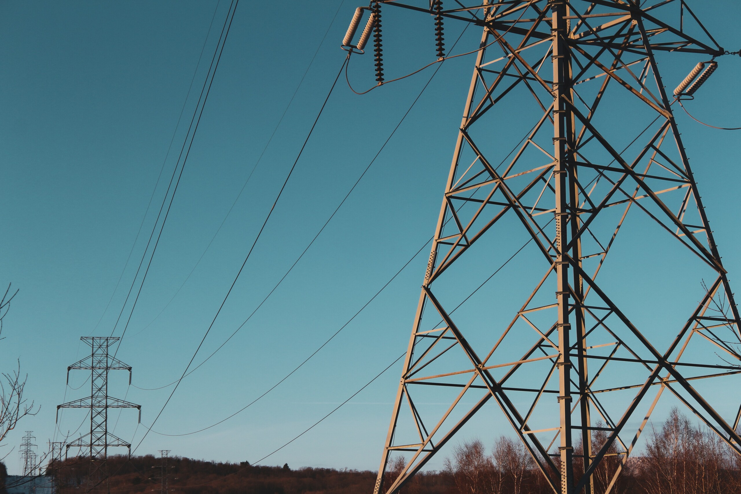 A line of electricity pylons with blue sky