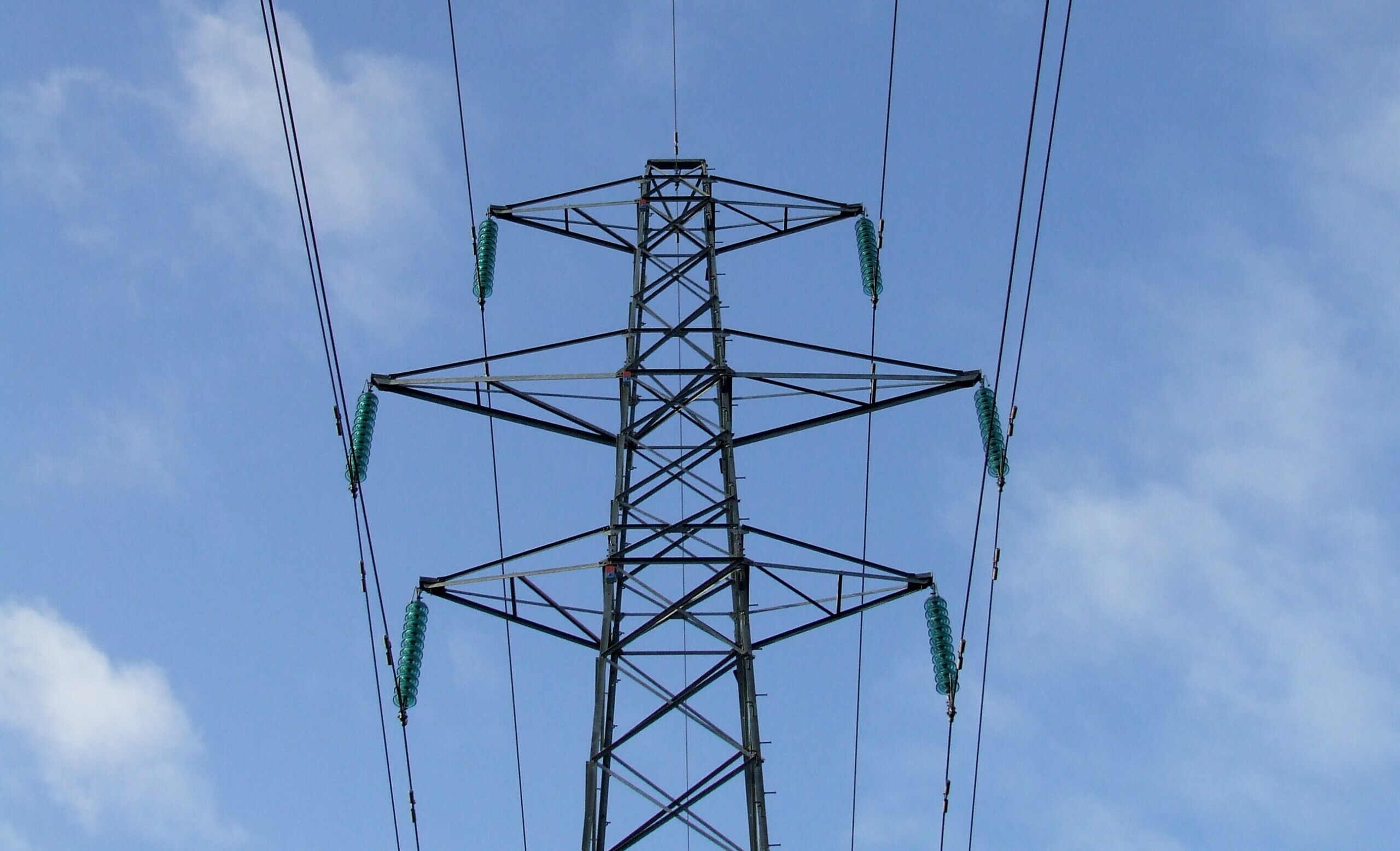 An electricity pylon against a blue sky.