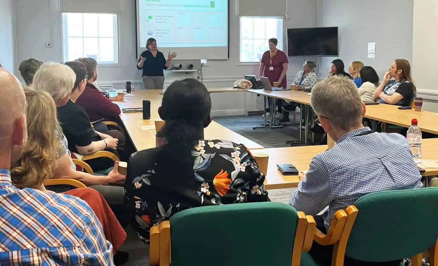 A group of people listening to a presentation