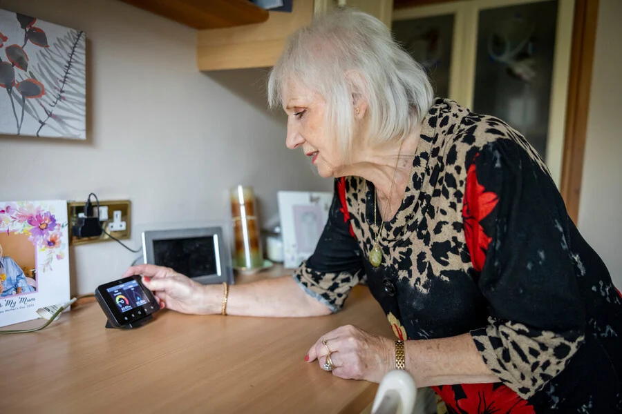 An older woman programming a smart meter.