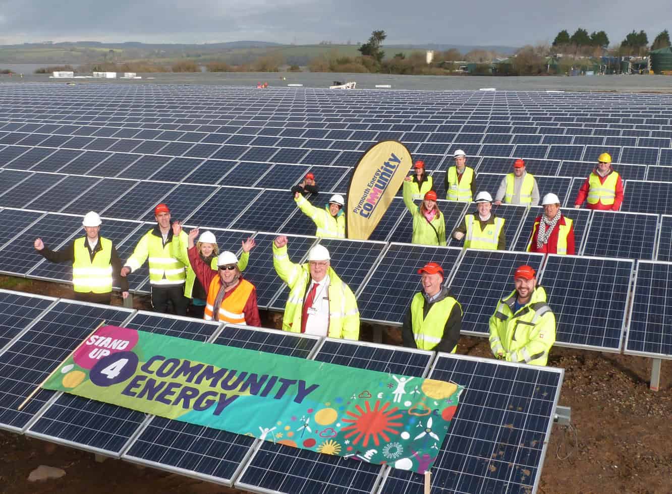 Drone-view of people in hi-viz jackets celebrating the opening of a community-owned solar field.