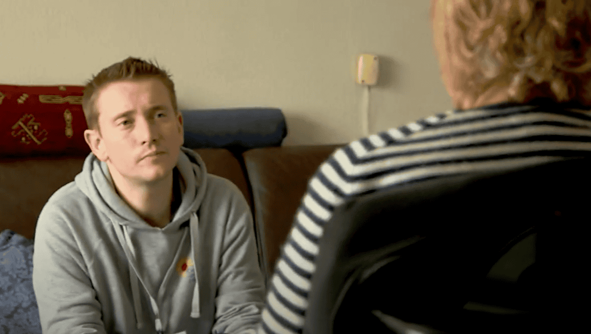 An energy advisor on a home visit listening to a client explaining her difficulties