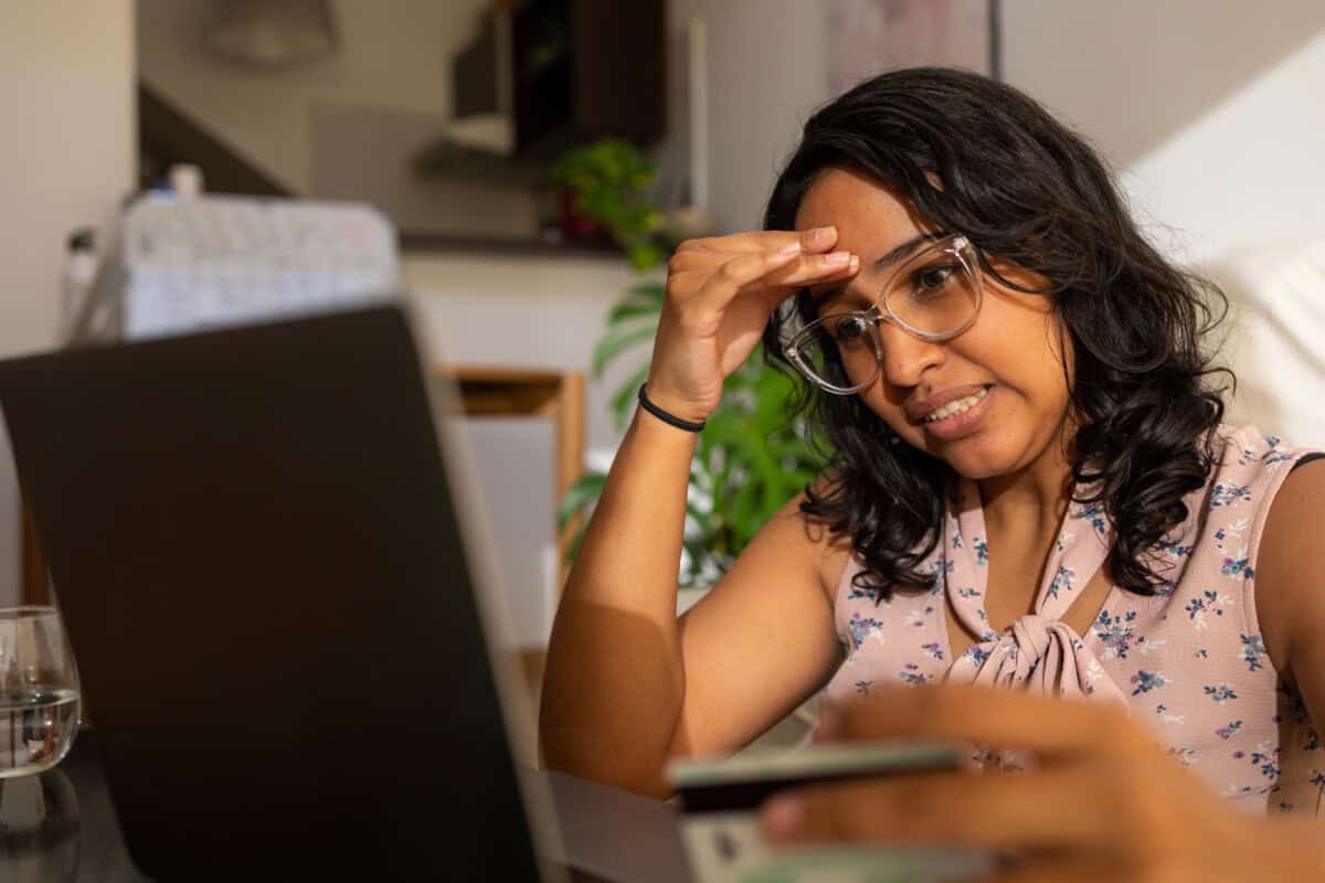 A worried woman looks at her laptop