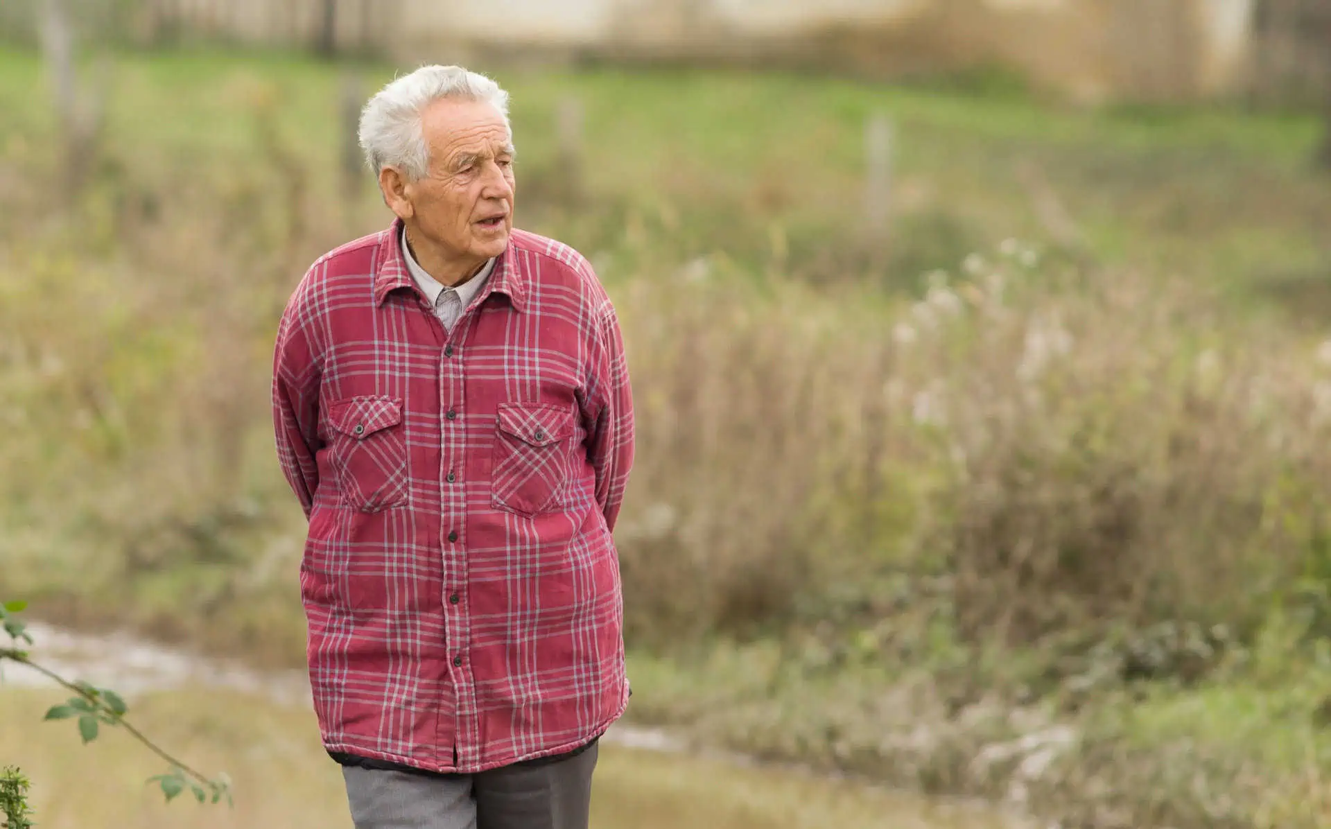 Elderly but active man walking walking in a rural location.