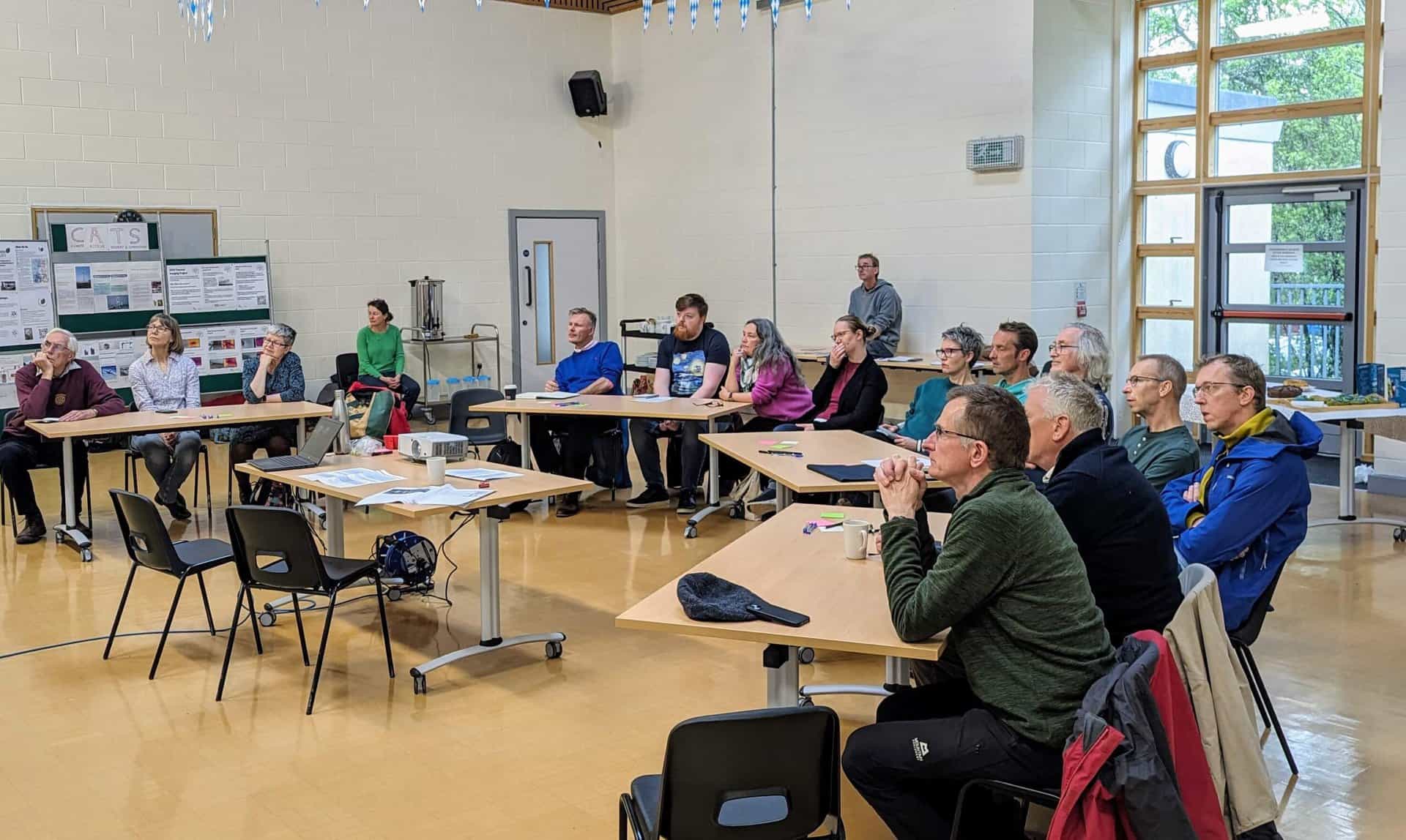 A large group of people sat at desks to attend a workshop.