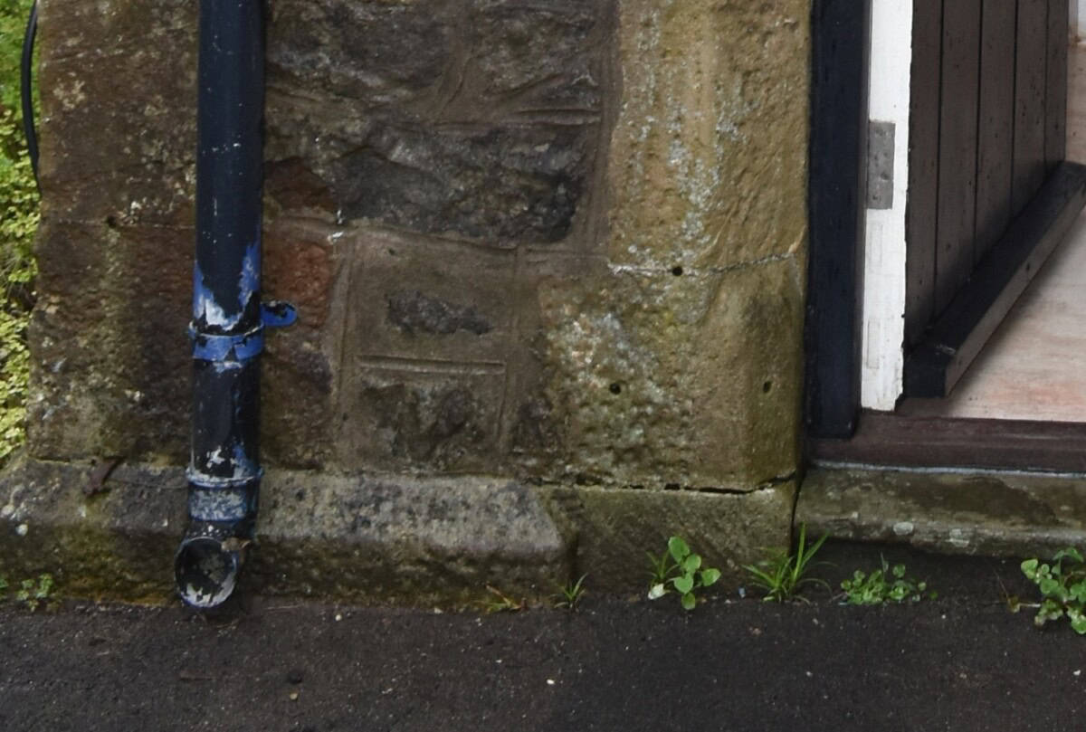 A gutter next to a damp stones on the external wall of an old listed home.
