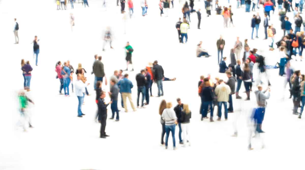 A scattered crowd of people in motion blur on white background