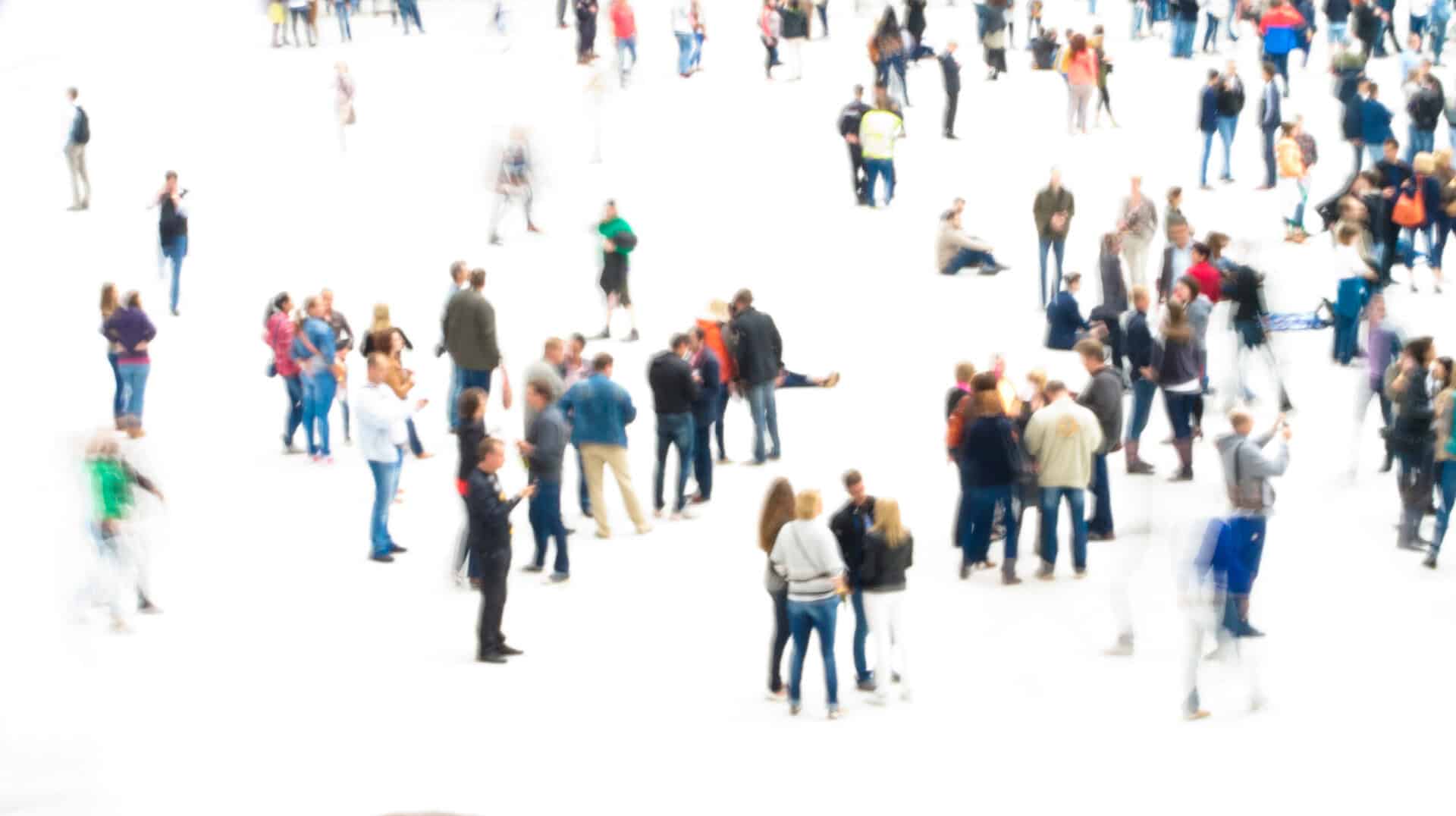 A scattered crowd of people in motion blur on white background