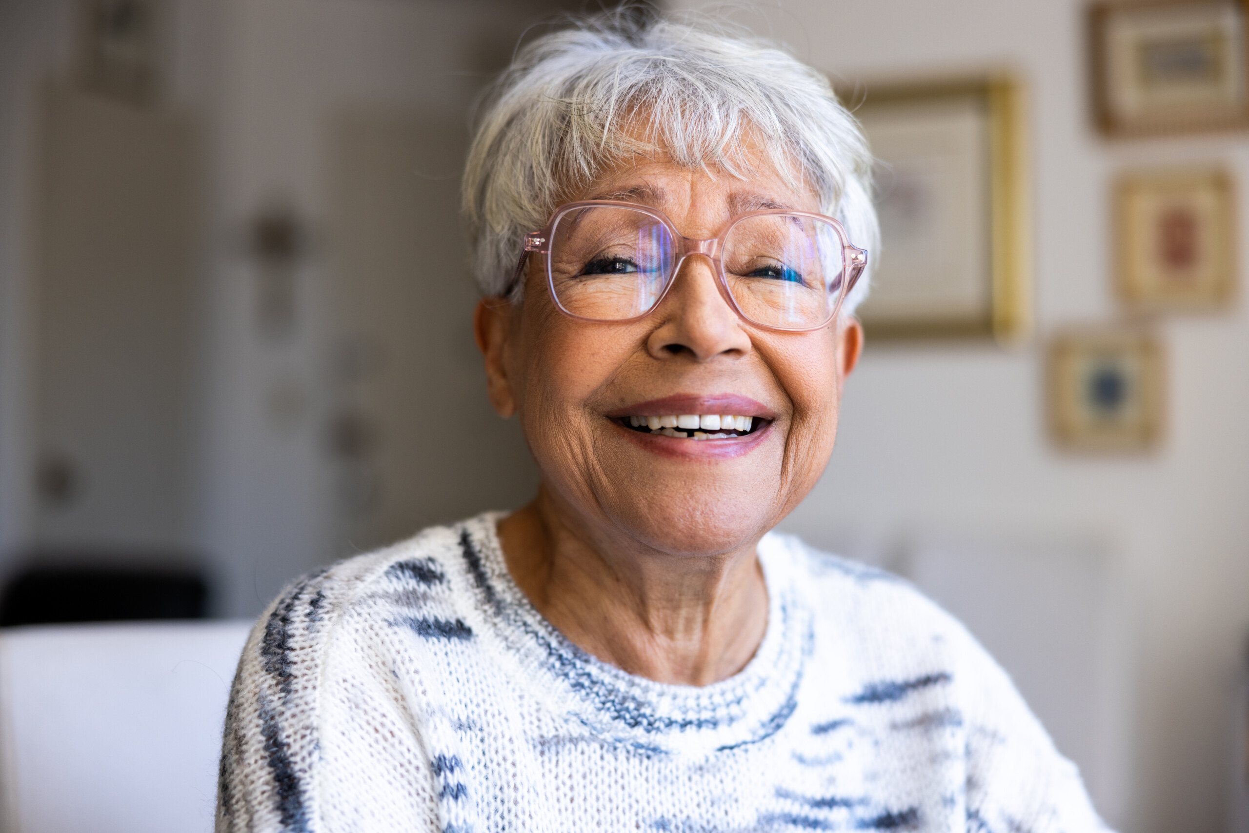 Older lady smiling in her house.