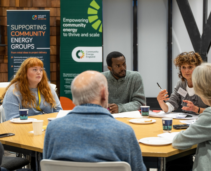 A group of 5 people sat around a circular wooden table during the networking section of a Seeing is believing went.