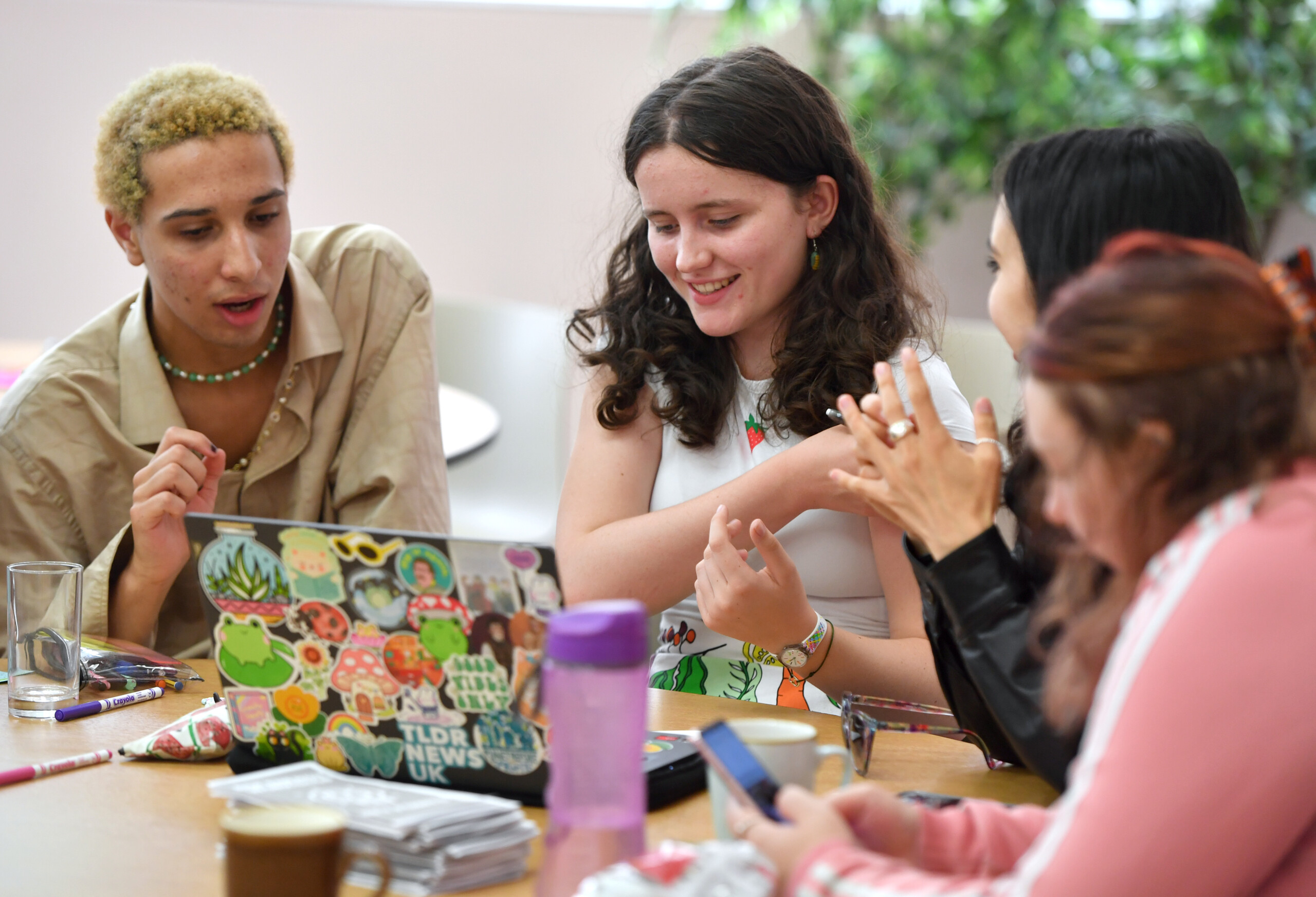 Young people talking and smiling around a table.