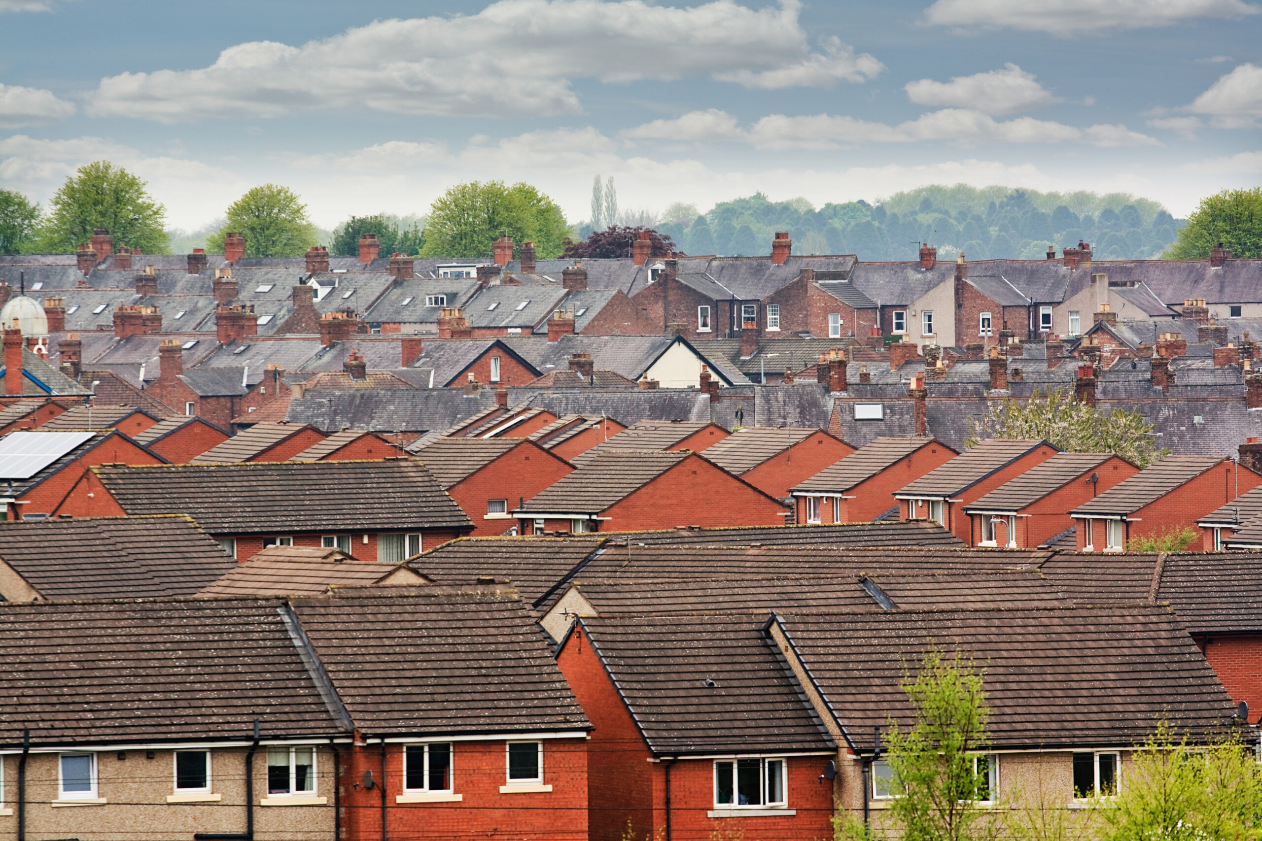 View over rooftops of ordinary homes in a town in England.