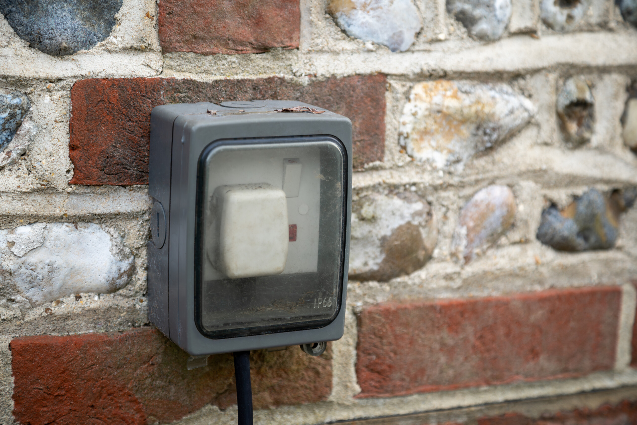 Outdoor plug socket on brick wall