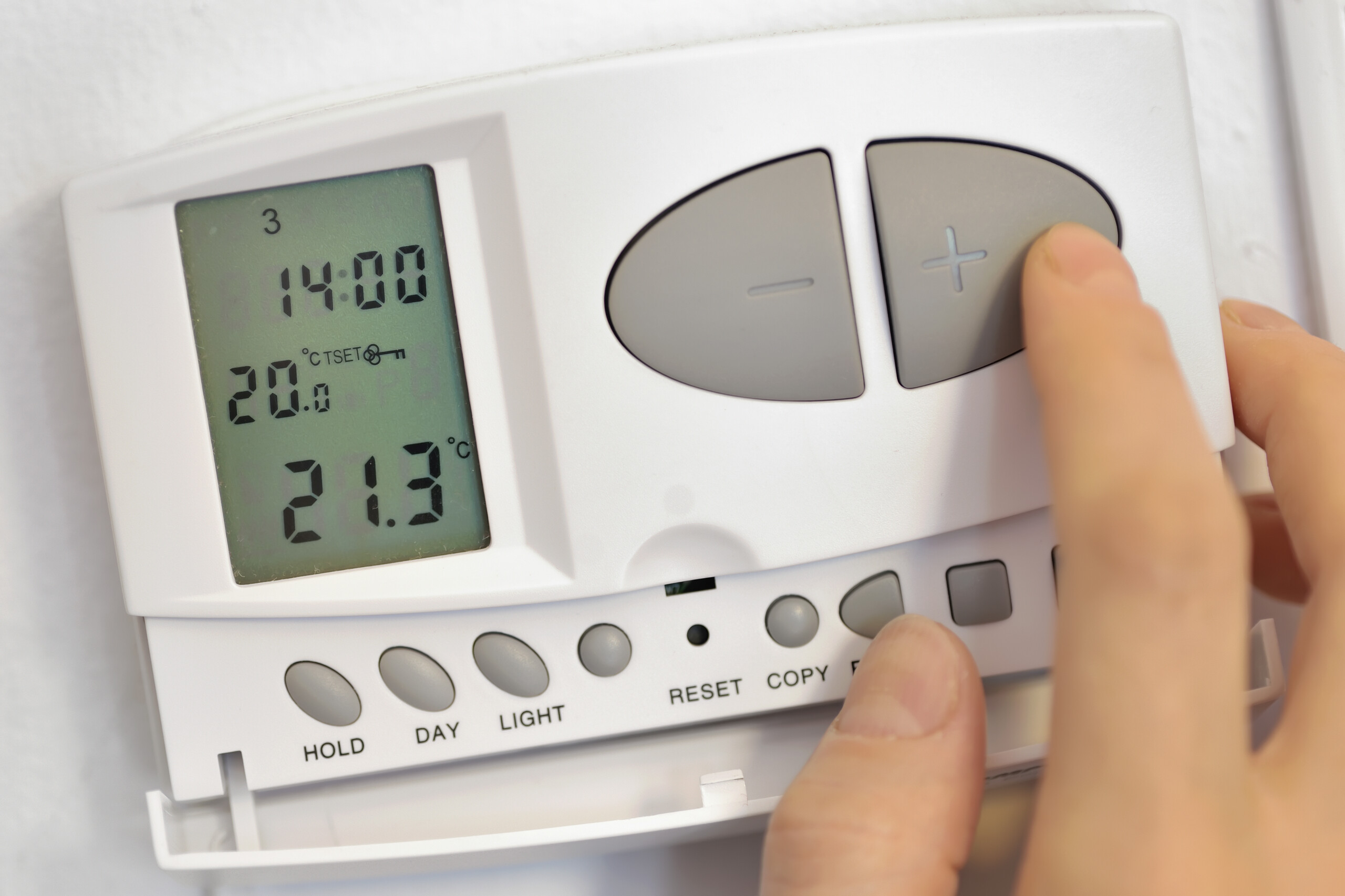 Close up of someone setting their central heating controls.