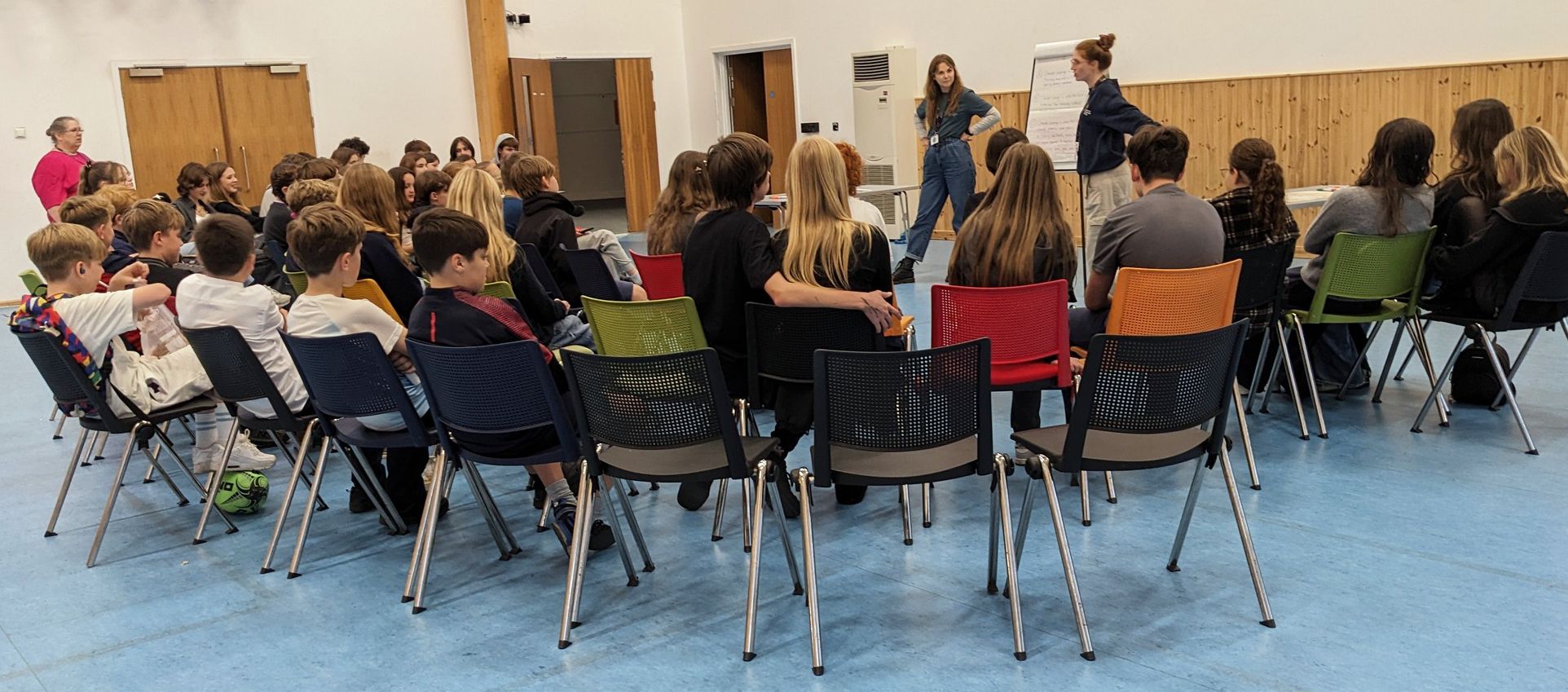 A group of 30-40 Key Stage 4 students listen to a presentation